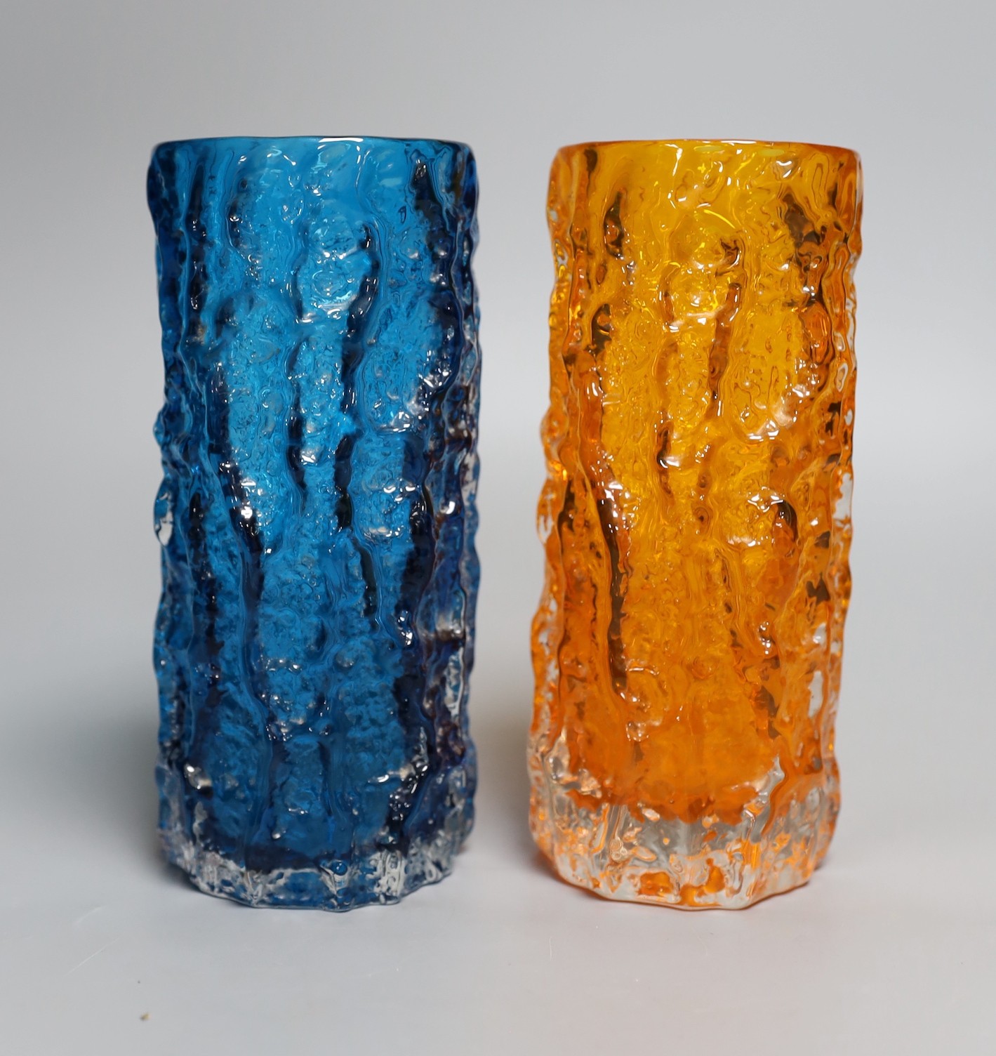 Two Whitefriars 'bark' cylinder vases, model 9689 designed by Geoffrey Baxter in 'tangerine' and 'kingfisher blue' glass, each 19cm high.